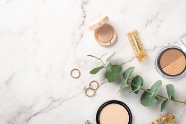 Makyaj konsepti. Beyaz mermer arka planda konturing palet göz fotografı kompakt toz toz altın halkalar tokalar ve okaliptüs filizi boş alan arkaplan