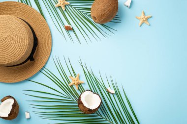 Summer holidays concept. Top view photo of headwear coconuts starfishes and palm leaves on isolated pastel blue background with copyspace