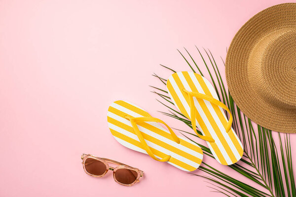 Летние выходные. Фото солнцезащитных очков с желтыми полосатыми тапочками и пальмовыми листьями на изолированном розовом фоне с копирайтом