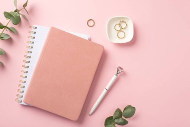 İş konsepti. İş yerinin en üst görüntüsü pembe notlar kız işi altın yüzükler ve izole edilmiş pembe arka planda okaliptüsler.