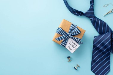 Babalar Günü konsepti. El işi kağıt hediye kutusunun üst görünümü kurdele yayı ve kartpostal kravat kol düğmeleri ve mavi kravat boş arkaplan ve izole pastel mavi arkaplan