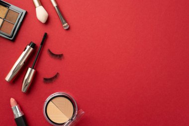 Makyaj güzellik konsepti. Göz falı düzenleyen ruj fotoğrafının üst görüntüsü sahte kirpikler ve kopyalanmış kırmızı arkaplan üzerindeki makyaj fırçaları