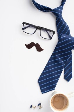Babalar Günü konsepti. Mavi kravat kol düğmeleri, bıyık ve izole edilmiş beyaz arka planda bir fincan kahve.