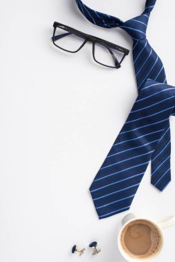 Babalar Günü konsepti. Üst görünümde mavi kravat kol düğmesi bardakları ve boş arkaplanda bir fincan kahve.