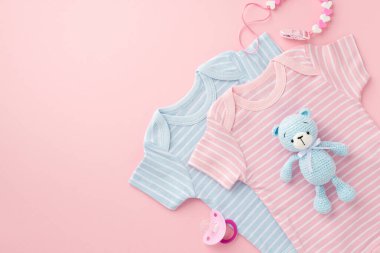 Bebek aksesuarları konsepti. Pembe ve mavi vücutlu bebeklerin kukla zinciri ve izole edilmiş pastel arka planda örülmüş oyuncak ayıcıklar.