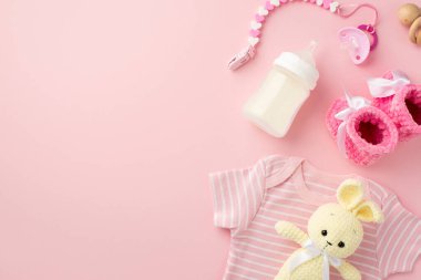 Bebek aksesuarları konsepti. Bebek kıyafetlerinin üst görüntüsü pembe gömlek paçaları zinciri yumuşatır sevimli örgü oyuncak oyuncak çıngırak ve şişe izole edilmiş pastel pembe arka plan boş alan