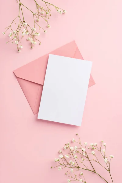 派对邀请的概念 粉色信封纸片与白色吉普赛花在孤立的带空隙的粉红背景上的顶视图垂直照片 — 图库照片