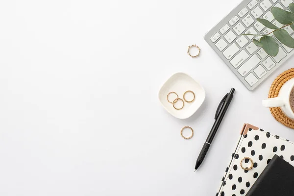 ビジネスコンセプト 職場のキーボード黒と白のトレンディーなノートブックのトップビューコピースペースと隔離された白い背景にマットゴールドリングとユーカリを提供籐上のコーヒーのペンカップ — ストック写真