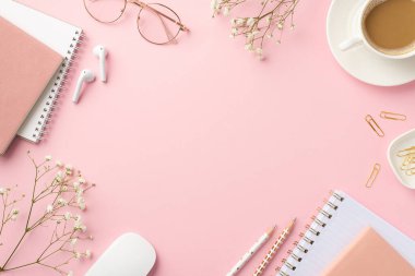 İşyeri kahve fincanının üst görüntüsü bilgisayar fare planlamacıları kalem, gözlük kulaklıklar ve izole edilmiş pastel pembe arka planda beyaz çıngıraklı çiçekler ortada boş alan.