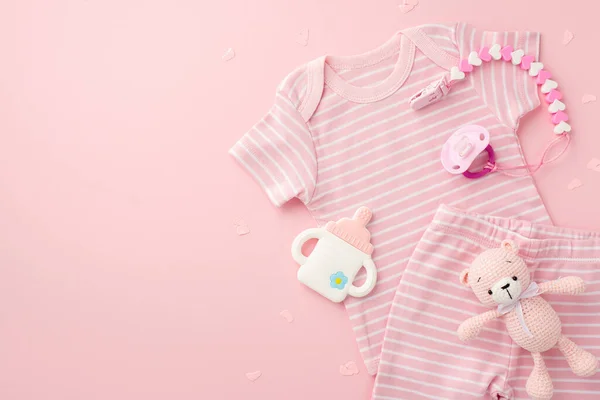 Baby accessories concept. Top view photo of pink shirt shorts baby's dummy chain bottle shaped teether and knitted bear toy on isolated light pink background with empty space