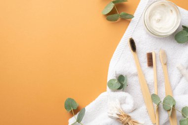 Diş fırçası kavanozunun üst görüntüsü. Diş macunu tomurcukları. Beyaz havlu ve okaliptüs.