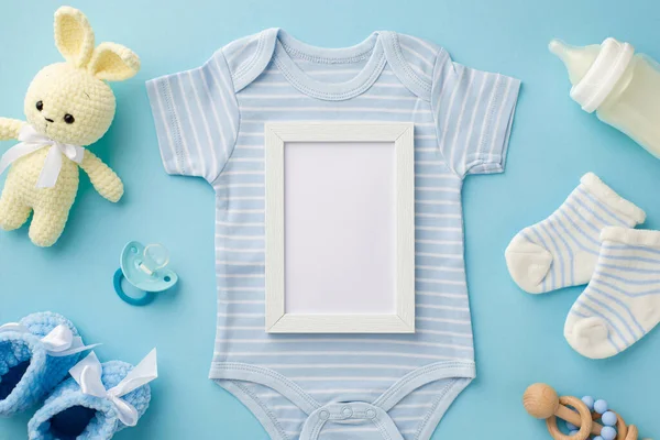 Bebek oğlan konsepti. Fotoğraf çerçevesi mavi vücut giysisi çoraplar örgü oyuncak süt şişesi tahta çıngıraklı oyuncak ayakkabılar ve izole edilmiş pastel mavi arka planda emzik.