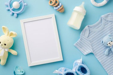 Bebek aksesuarları konsepti. Fotoğraf çerçevesi örgü tavşan ve ayı oyuncağı mavi gömlek süt şişesi çıngıraklı ayakkabılar ve bebeğin kuklası.