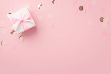 Gender party concept. Top view photo of white giftbox with ribbon bow and shiny confetti on isolated pastel pink background with empty space