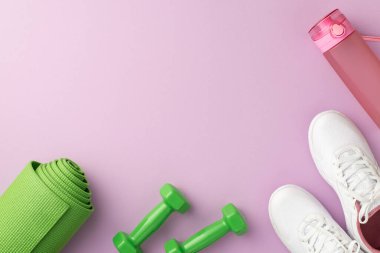 Fitness konsepti. Yeşil yoga minderinin üst görüntüsü halterler pembe su şişesi ve beyaz spor ayakkabıları izole edilmiş pastel menekşe arka plan boş alan