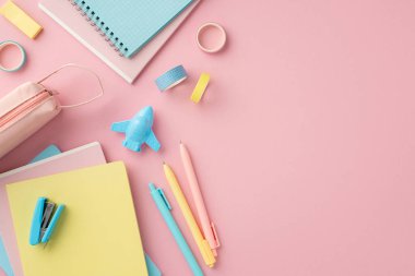 Back to school concept. Top view photo of colorful notepads pens plane shaped sharpener adhesive tape stapler pencil-case and sticky bookmarks on isolated pink background with copyspace