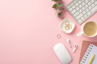 İş konsepti. İş yerindeki klavye bilgisayarının en iyi görüntüsü fare bardağı sıcak içme kablosuz kulaklıklar altın halkalar kalem planlayıcılar ve okaliptüs yaprakları kopyalanmış pembe arka planda