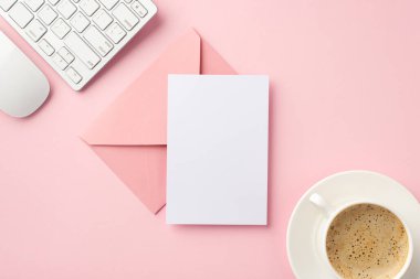 İş konsepti. İşyeri klavyesinin üst görüntüsü bilgisayar faresi fincanı çay tabağı pembe zarf üzerinde kahve ve izole edilmiş pastel pembe arkaplan üzerinde kopya uzay ile kağıt tabaka
