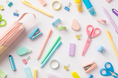 School supplies concept. Top view photo of scattered stationery correction pens pink pencil-case staplers binder clips adhesive tape scissors sharpeners and erasers on isolated white background