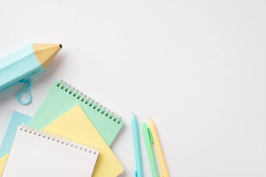 Okul konseptine geri dönelim. Renkli okul aksesuarlarının en iyi görüntüsü izole edilmiş beyaz arkaplan üzerinde mavi kalem ve defter yığını