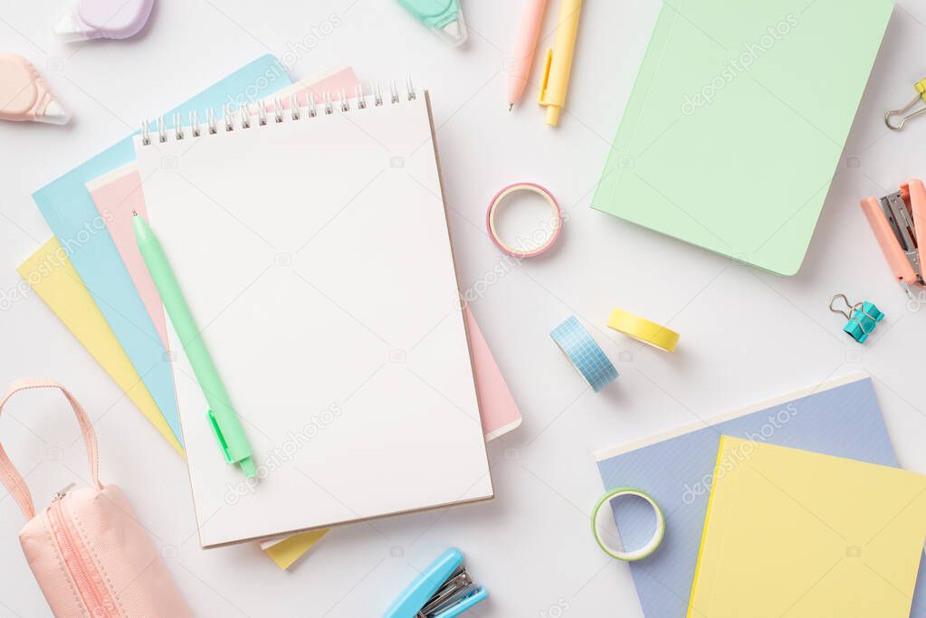 Back to school concept. Top view photo of notepads pen pencil-case mini staplers adhesive tape round correction tape and binder clips on isolated white background with blank space