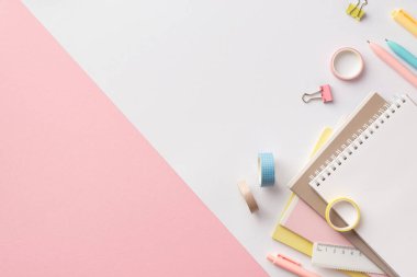 Okul konseptine geri dönelim. Renkli okul malzemelerinin üst görünümü planlayıcılar cetvel klasörü ve iki renkli pembe ve beyaz arkaplan üzerine yapıştırıcı bant boş alan