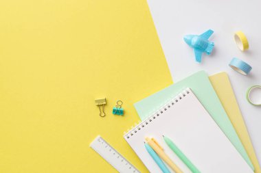 Back to school concept. Top view photo of colorful school supplies plane shaped sharpener pens ruler adhesive tape and binder clips on bicolor yellow and white background