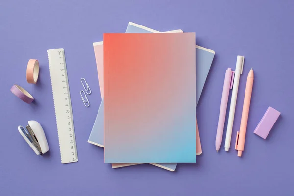 School supplies concept. Top view photo of stylish gradient color diary pens adhesive tape stapler ruler clips and eraser on isolated violet background