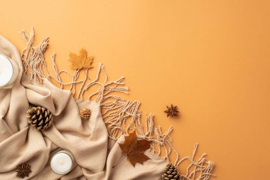 Autumn aesthetic concept. Top view photo of yellow maple leaves plaid anise pine cones and candles on isolated orange background