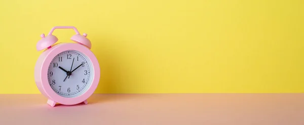 Panoramic Photo Pink Alarm Clock Pink Desk Yellow Wall Background — Stockfoto