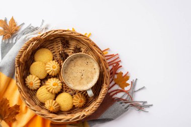 Autumn mood concept. Top view photo of wicker tray with cup of frothy hot chocolate homemade cookies anise fallen maple leaves and plaid on isolated white background