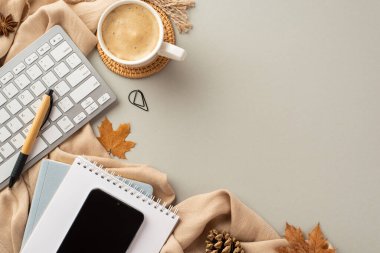 Autumn business concept. Top view photo of reminders pen clip mobile phone keyboard cup of coffee on rattan serving mat anise fallen maple leaves pine cone and plaid on isolated grey background