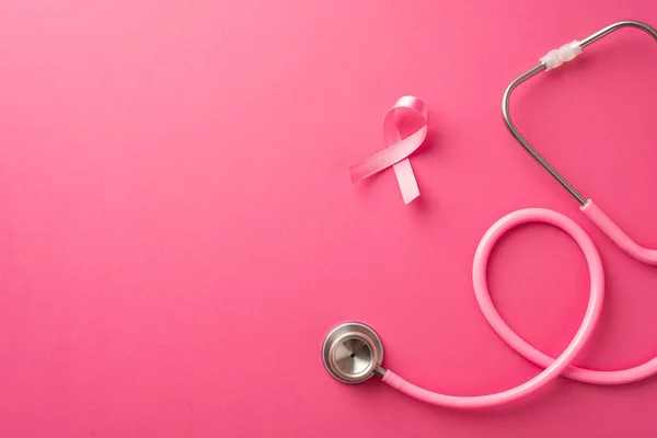 Breast cancer prevention concept. Top view photo of pink silk ribbon and stethoscope on isolated pink background with copyspace