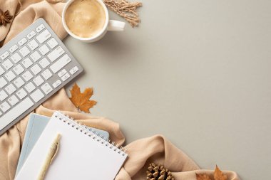 Autumn business concept. Top view photo of workstation notepads pen keyboard cup of coffee anise yellow maple leaves pine cone and scarf on isolated grey background