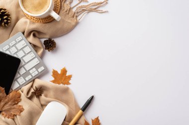 Top view photo of workstation keyboard computer mouse mobile phone cup of coffee on rattan serving mat pen fallen maple leaves pine cones anise and scarf on isolated white background with copyspace