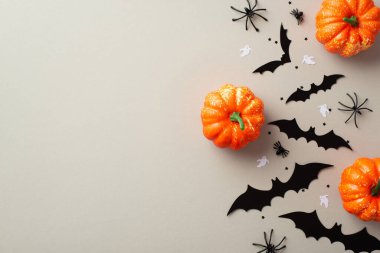 Halloween creepy decorations concept. Top view photo of pumpkins spiders bats ghost silhouettes and confetti on isolated grey background with empty space