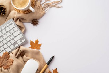 Top view photo of workstation keyboard computer mouse cup of coffee on rattan serving mat pen yellow maple leaves pine cone anise and scarf on isolated white background with copyspace