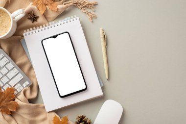 Autumn business concept. Top view photo of smartphone over notepad computer mouse keyboard pen cup of coffee yellow maple leaves anise pine cone and plaid on isolated grey background with blank space