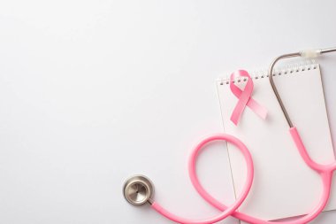 Göğüs kanseri farkındalığı konsepti. Pembe ipek kurdele steteskop ve izole edilmiş beyaz arkaplanda not defteri.