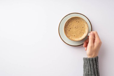 Sonbahar konsepti. Gri kazaklı bir kızın, izole edilmiş beyaz arka planda sıcak bir bardak sıcak su içerken çekilmiş ilk resmi.