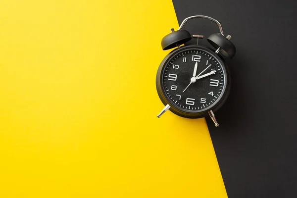 サイバー月曜日のコンセプト コピースペース付き2色の黄色と黒の背景に黒の目覚まし時計のトップビューの写真 — ストック写真