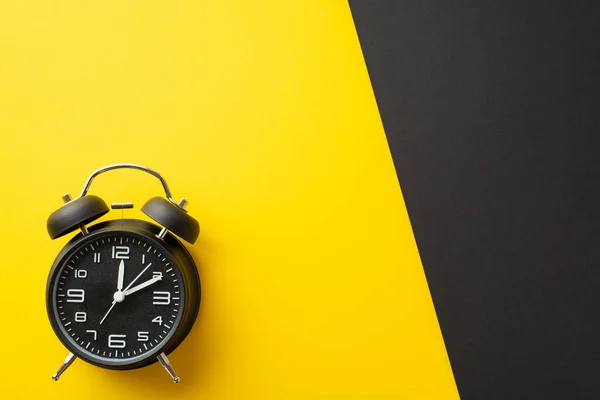 ブラックフライデーのコンセプト 黒の目覚まし時計のトップビューの写真2色の黄色と空白のスペースと黒の背景 — ストック写真