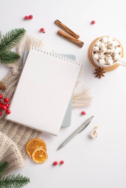 Kış konsepti Üstten bakıldığında, üzerinde marshmallow ladin dalları olan bir fincan sıcak çikolatanın dikey fotoğrafı ökseotu tarçın dilimleri ve izole edilmiş beyaz arka planda eşarp.