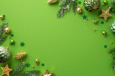 Noel ağacı süslemeleri konsepti. Altın ve yeşil mücevherlerin en üstteki fotoğrafı kozalak ve köknar dallarını tenha yeşil arka planda boş alanla donduran konfeti süslüyor.