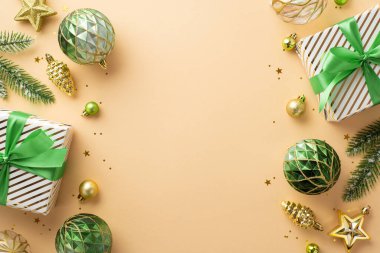 Yeni yıl konsepti. Kurdeleli mevcut kutuların üst görüntüsü altın ve yeşil takılar çam yıldızı süslemeleri ladin dalları ve tenha bej arka planda boş alan konfetileri