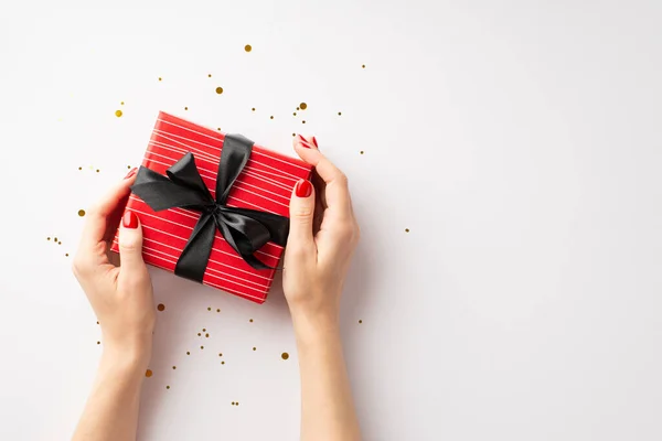 黑色星期五购物的概念 在第一张照片中 女孩的手拿着红色礼品盒 上面有彩带蝴蝶结和金光闪闪的领带 背景是孤立的白色 — 图库照片