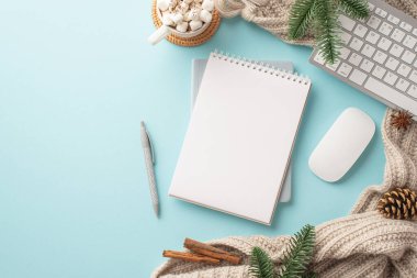 İşyeri klavyesinin en üst görüntüsü bilgisayar faresi kalem bardağı marshmallow örülmüş ladin dalları çam kozalağı tarçın çubukları ve kopyalanmış pastel mavi arka plan