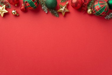 Yeni yıl konsepti. Kırmızı yeşil ve altın takılar yıldız süslemeleri ökse otu üzümleri ve çam dalları izole edilmiş kırmızı arkaplanda, kopyalanmış kırmızı arkaplanda.