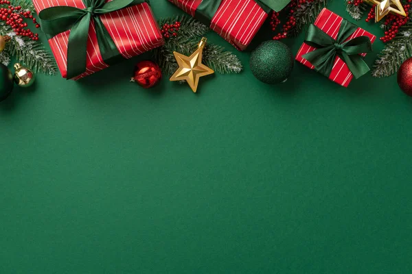 New Year concept. Top view photo of red gift boxes with green ribbon bows baubles gold star ornaments mistletoe berries and pine branches in snow on isolated green background with empty space