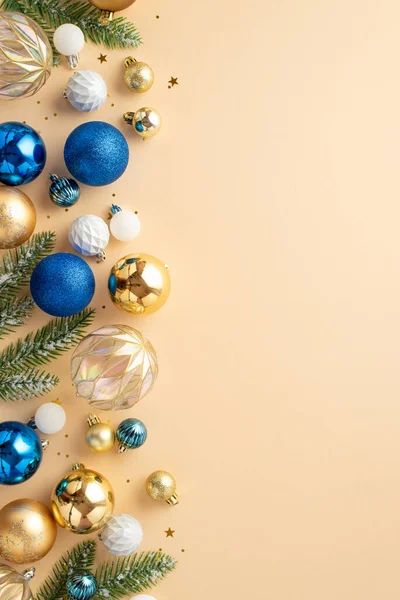 Christmas tree decorations concept. Top view vertical photo of fir branches in hoarfrost white transparent blue gold baubles and sequins on isolated beige background with copyspace